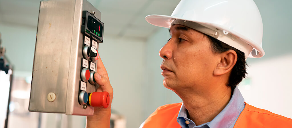 Empleado haciendo ajustes en el sistema de ejecución de fabricación Empleado haciendo ajustes en el sistema de ejecución de fabricación